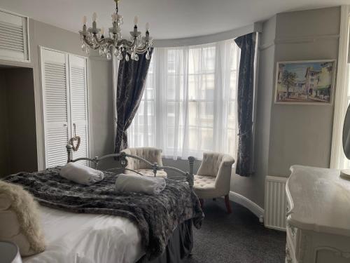 um quarto com uma cama e um lustre em Beautiful Seaview 2 Bedroom Apartment em Brighton & Hove