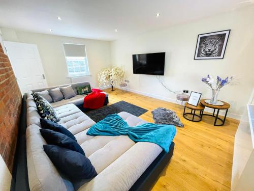 a living room with a couch and a tv at 75 Weavers Townhouse in Norwich
