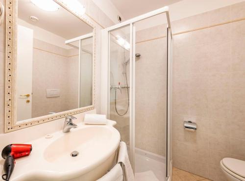 ein Bad mit einem Waschbecken und einer Dusche in der Unterkunft Hotel La Perla in Tremezzo