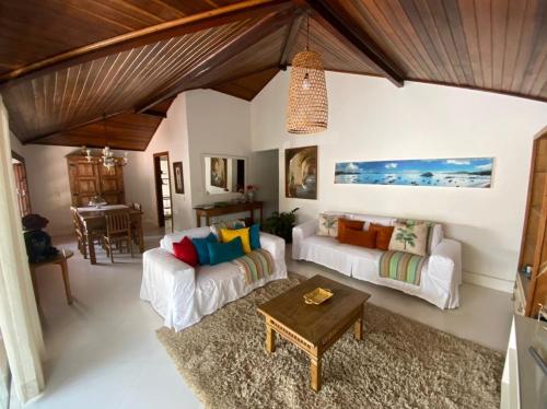 a living room with two white couches and a table at Casa de praia tranquilidade e conforto in Búzios