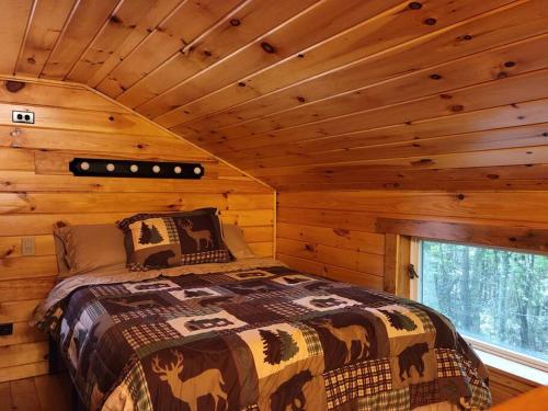 1 dormitorio con 1 cama en una cabaña de madera en Vana Kuti-cabin in the woods, en Camden