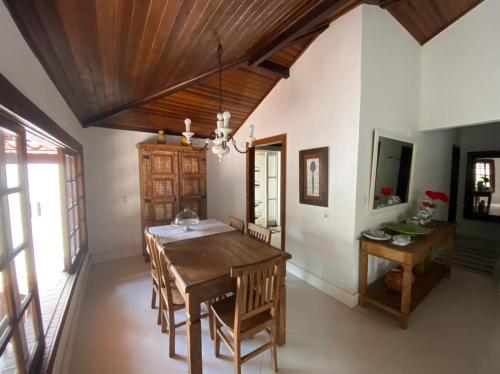 a dining room with a wooden table and chairs at Casa de praia tranquilidade e conforto in Búzios