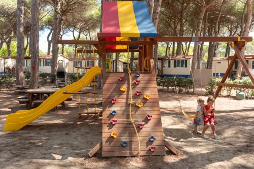 two children are playing on a playground at Pineta Sul Mare Camping Village in Cesenatico