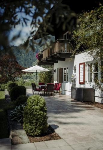 a patio with a table and chairs and an umbrella at Chalet Lerch in Sankt Johann im Pongau
