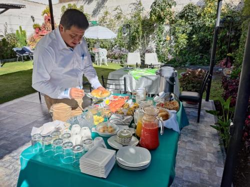 un hombre preparando comida sobre una mesa en Casa Baraquel, en Arequipa