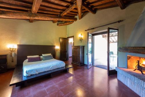ein Schlafzimmer mit einem Bett und einem Kamin in der Unterkunft Sur la Colline in Foglia