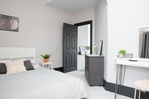 a white bedroom with a bed and a mirror at Beautiful first floor apartment in Poulton le Fylde