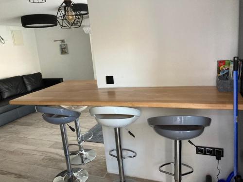 a kitchen with a counter and two stools under it at Trinity in Balatonalmádi