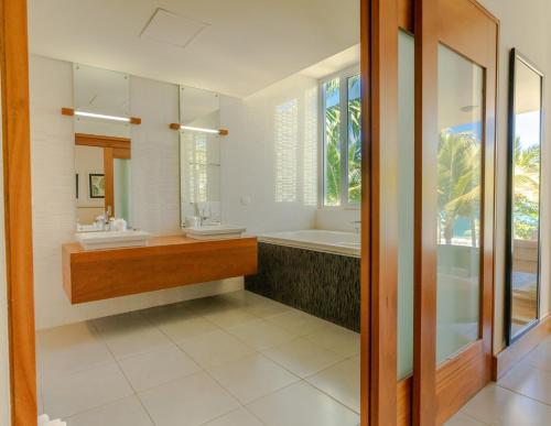 a bathroom with two sinks and a bath tub at Ultravioleta Boutique Residences in Cabarete