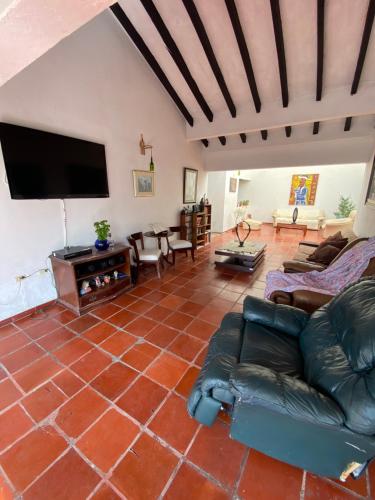 a living room with a couch and a flat screen tv at Hacienda La Pola in Guaduas
