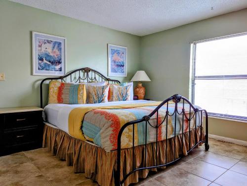 a bedroom with a bed in a room with a window at Sea Club Condo #6 in Clearwater Beach