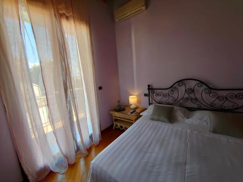 a bedroom with a bed and a large window at B&B Villa Letizia in San Vito Rimini