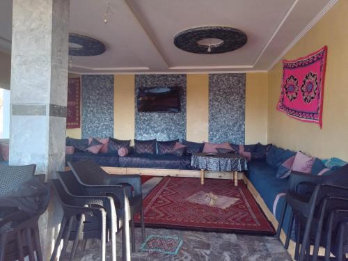 a living room with a couch and a table and chairs at Gîte Forest Tagroumte in Azrou