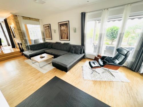a living room with a black couch and chairs at Exclusive High-quality Apartment Spessart in Marktheidenfeld