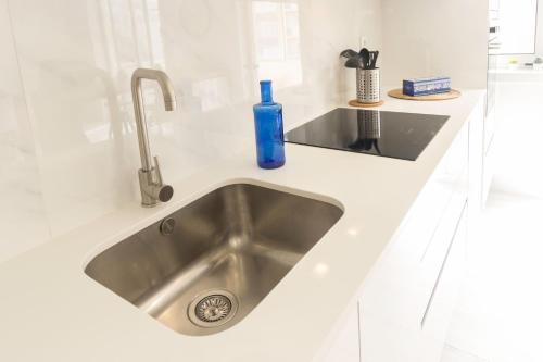 a kitchen sink with a blue bottle on it at Guest H4U POVOA SUMMER HOLIDAYS in Póvoa de Varzim