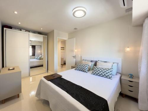 1 dormitorio con 1 cama blanca grande y espejo en Lindo Flat com Varanda e Vista Panorâmica no Coração da Barra Pertinho de Tudo B1-0029, en Río de Janeiro