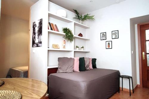 a room with a couch and a table and shelves at Estudio Lavapiés cerca de Antón Martín in Madrid