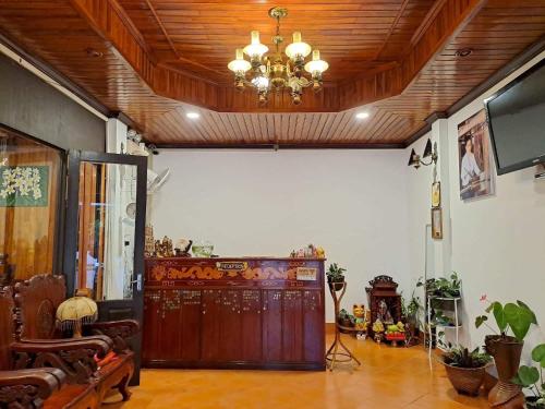 a living room with a wooden door and a chandelier at Chaliya Boutique Garden in Luang Prabang