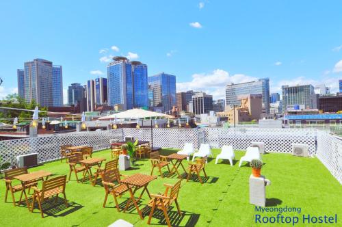 un grupo de mesas y sillas en el tejado de un edificio en OYO Rooftop Hostel, en Seúl