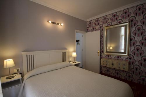 Un dormitorio con una cama blanca y un espejo. en Apartament Drago Sunrises, en Costa del Silencio