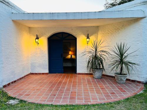 a front door of a house with two potted plants at La Mansa Riverside in Esquina