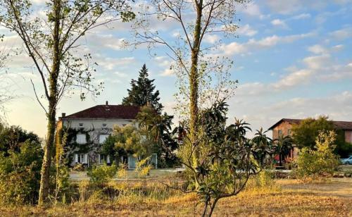 an old house with trees in front of it at Le parc de Gouts in Aiguillon