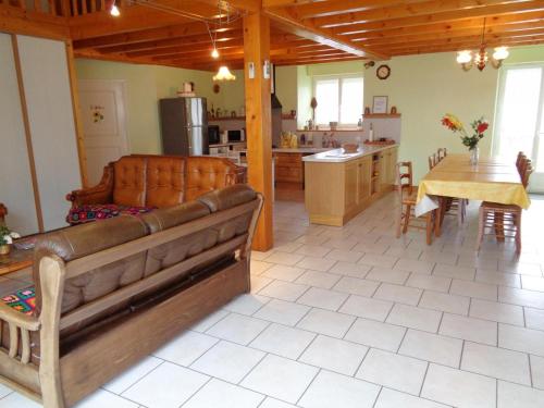 a living room and kitchen with a couch and a table at Gite de la croix in Apinac