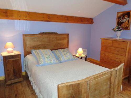 a bedroom with a bed with blue walls and two lamps at Gite de la croix in Apinac