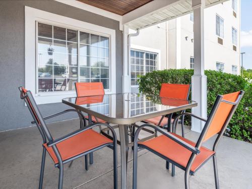 a glass table and chairs on a porch with a window at Country Inn & Suites by Radisson, Toledo, OH in Maumee