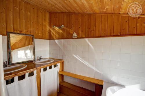 a bathroom with two sinks and a mirror at Les blancs moutons in Gumières