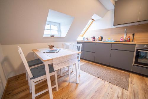 kuchnia ze stołem i krzesłami w pokoju w obiekcie FULL HOUSE Premium Apartments - Zwickau rooftop w mieście Zwickau