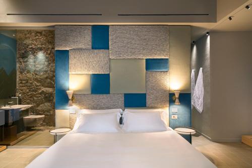 a bedroom with a large white bed and a bathroom at BASTIÒ PRIVATE SUITES in Catania