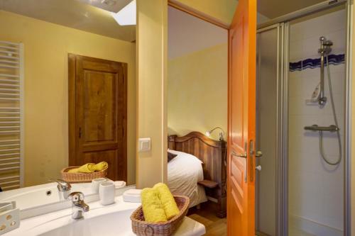 a bathroom with a sink and a mirror and a bed at Le clos du martouret in Roisey