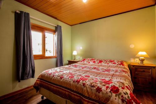 1 dormitorio con cama y ventana en Familiar da Colina - My Home Temporada, en Gramado