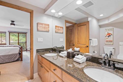 a bathroom with two sinks and a bedroom with a bed at St James Place by East West Hospitality in Beaver Creek
