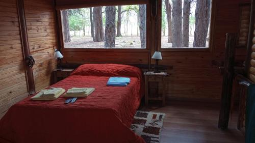 um quarto com 2 camas num chalé de madeira em Cabaña de Duendes em San Rafael