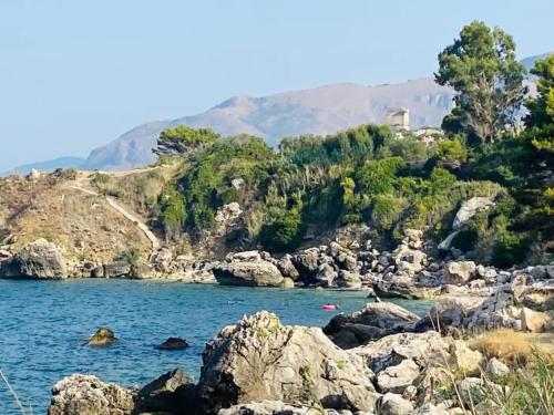 a view of a river with rocks and trees at Water Front Scopello in Scopello