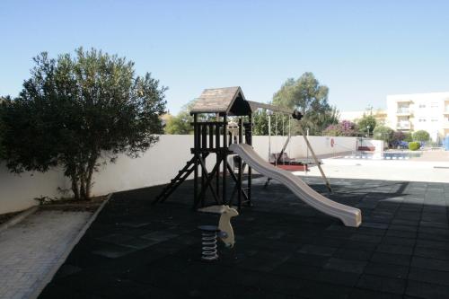 a playground with a slide and a playset at Apartament Franmar in Sant Jaume d'Enveja