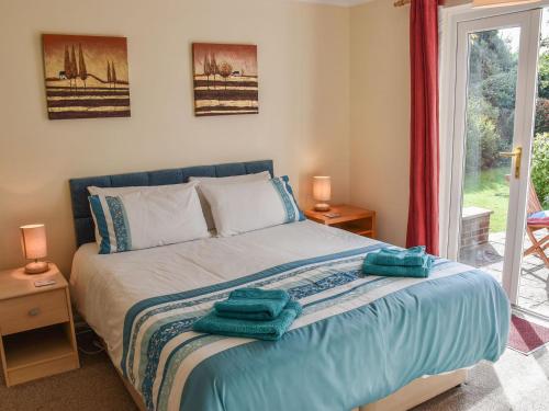 a bedroom with a bed with two towels on it at Montana Cottage in Happisburgh