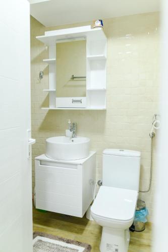 a white bathroom with a sink and a toilet at Apartman Dina in Soko Banja