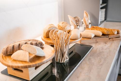 a counter with several plates of bread and pastries at São Paulo Tatuape, Affiliated by Meliá in Sao Paulo