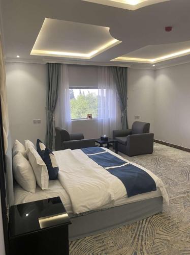 a bedroom with a large bed and a living room at قرين فيو للشقق المخدومة in Abha