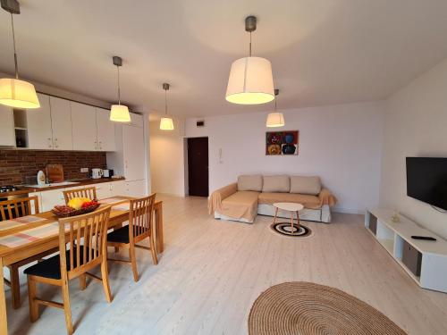 eine Küche und ein Wohnzimmer mit einem Tisch und einem Sofa in der Unterkunft CENTRAL Apartament Urbana in Arad
