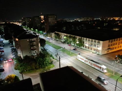 Eine Stadtstraße bei Nacht mit Autos und einem Bus in der Unterkunft CENTRAL Apartament Urbana in Arad