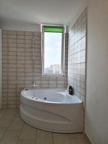 a white bath tub in a bathroom with a window at CENTRAL Apartament Urbana in Arad