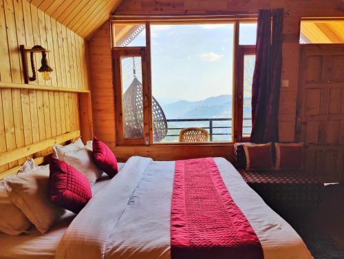 a bedroom with a large bed with a large window at Gadegal Homestay Narkanda - Rooms & Pahadi Café in Shimla
