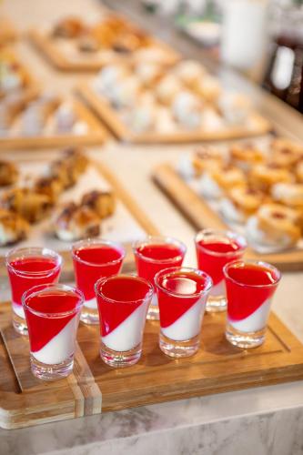 a group of red and white cups on a wooden tray at São Paulo Tatuape, Affiliated by Meliá in Sao Paulo