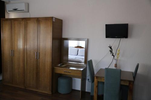 a room with a desk and a cabinet and a mirror at Hotel Antika in Prizren