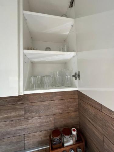 a kitchen with white walls and wooden cabinets at Holiday House Strawberry in Druskininkai