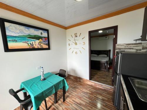 a room with a table and a clock on the wall at Posada Ashanty in Providencia